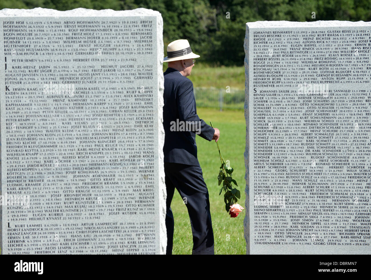 A relative stands with a rose at a granite slab with the names of fallen German soldiers during the dedication of the German military cemetery in Dukhovshchina, Smolensk Oblast, Russia, 03 August 2013. The cemetery is the last resting place for 70,000 German soldiers who died in Russia during World War II. Photo: UWE ZUCCHI Stock Photo