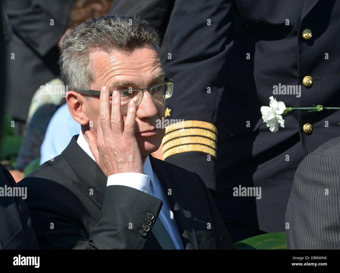 German Defence Minister Thomas de Maiziere wipes his eye during the dedication of the German military cemetery in Dukhovshchina, Smolensk Oblast, Russia, 03 August 2013. The cemetery is the last resting place for 70,000 German soldiers who died in Russia during World War II. Photo: UWE ZUCCHI Stock Photo
