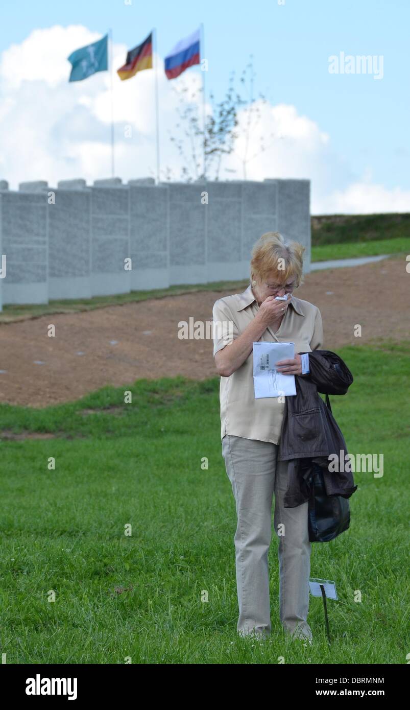 A relative walks past granite slabs with the names of fallen German soldiers during the dedication of the German military cemetery in Dukhovshchina, Smolensk Oblast, Russia, 03 August 2013. The cemetery is the last resting place for 70,000 German soldiers who died in Russia during World War II. Photo: UWE ZUCCHI Stock Photo