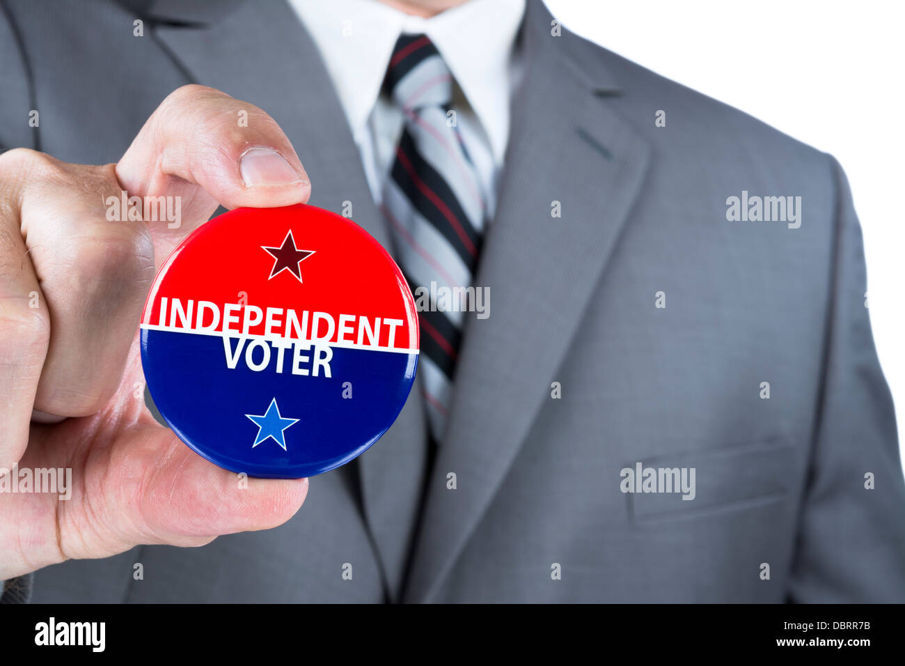 A man in a business suit holds out a political independent voter pin during elections. Stock Photo