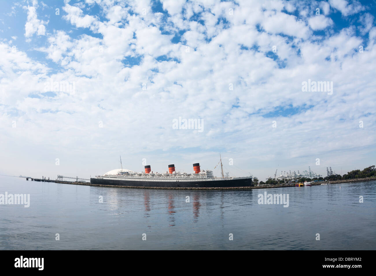 Puffy white clouds against a blue sky surround the Queen Mary in Long Beach, California. Stock Photo