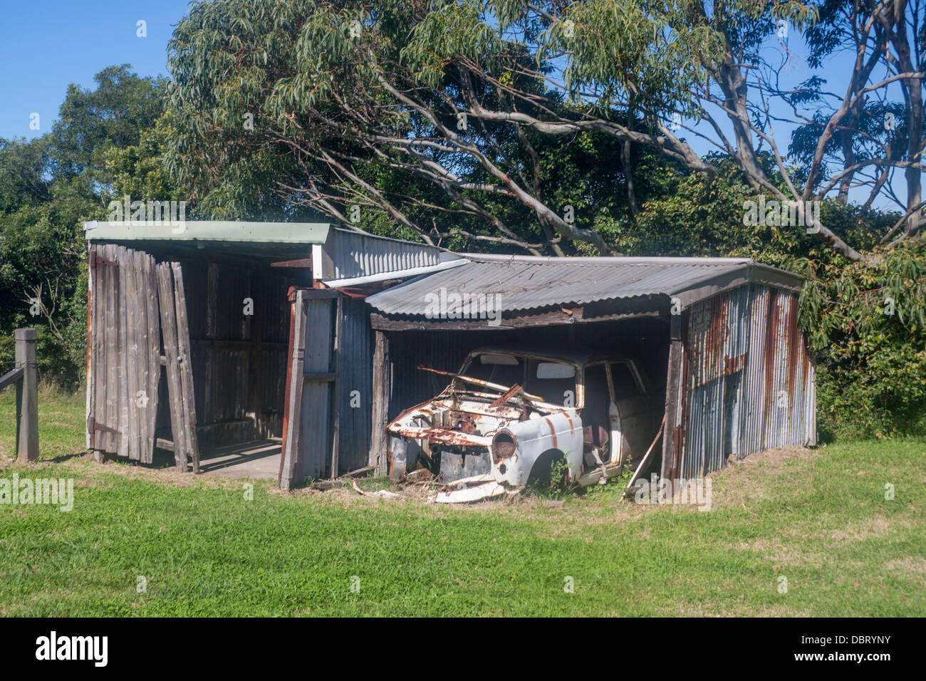 Ramshackle ruined wrecked old car in old corrugated iron tin shack garage Newcastle New South Wales NSW Australia Stock Photo