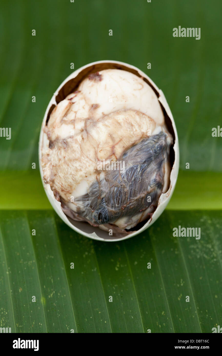 A partially opened balut, or fertilized duck egg, pictured on a banana leaf in Oriental Mindoro, Philippines. Stock Photo