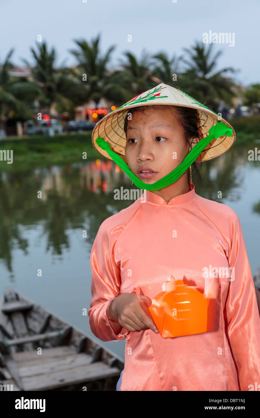 A young girl selling floating candles near the Japanese Bridge in Hoi