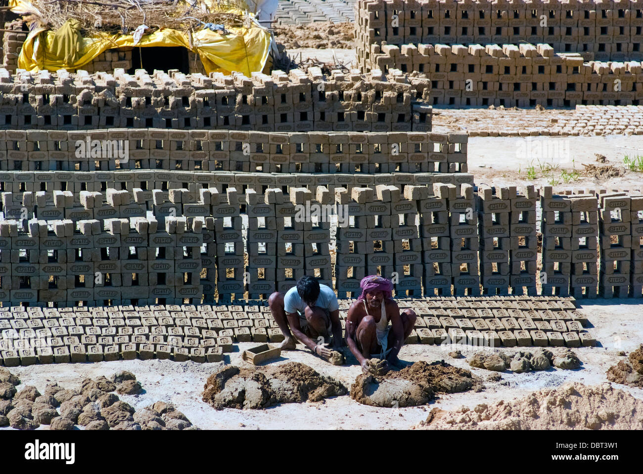 Labourers prepare bricks at a brick kiln on March 2, 2013, in Uttar Pradesh, India. Stock Photo