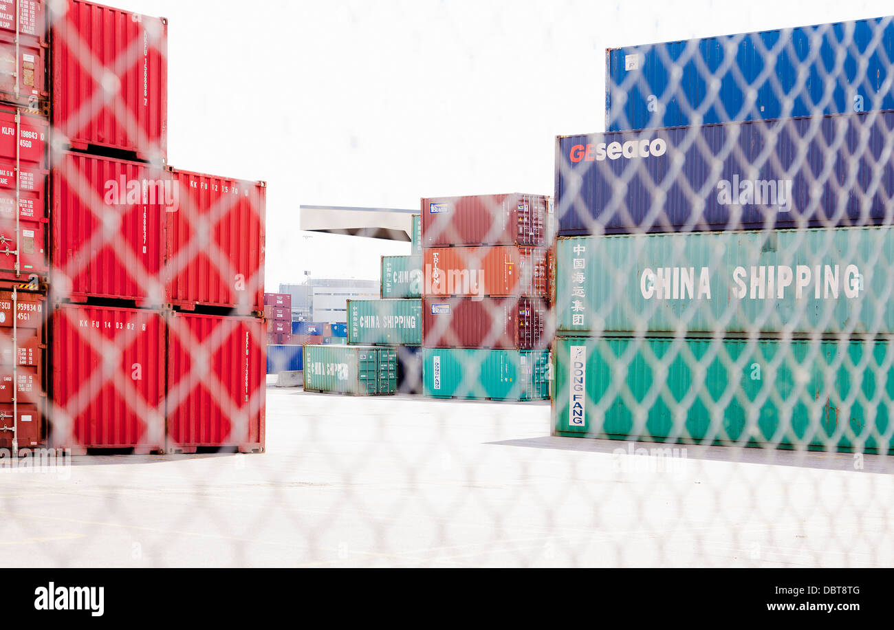 Cargo containers behind fence Stock Photo