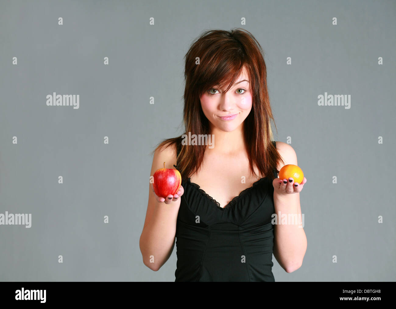 beautiful teen girl holding apple and orange Stock Photo - Alamy