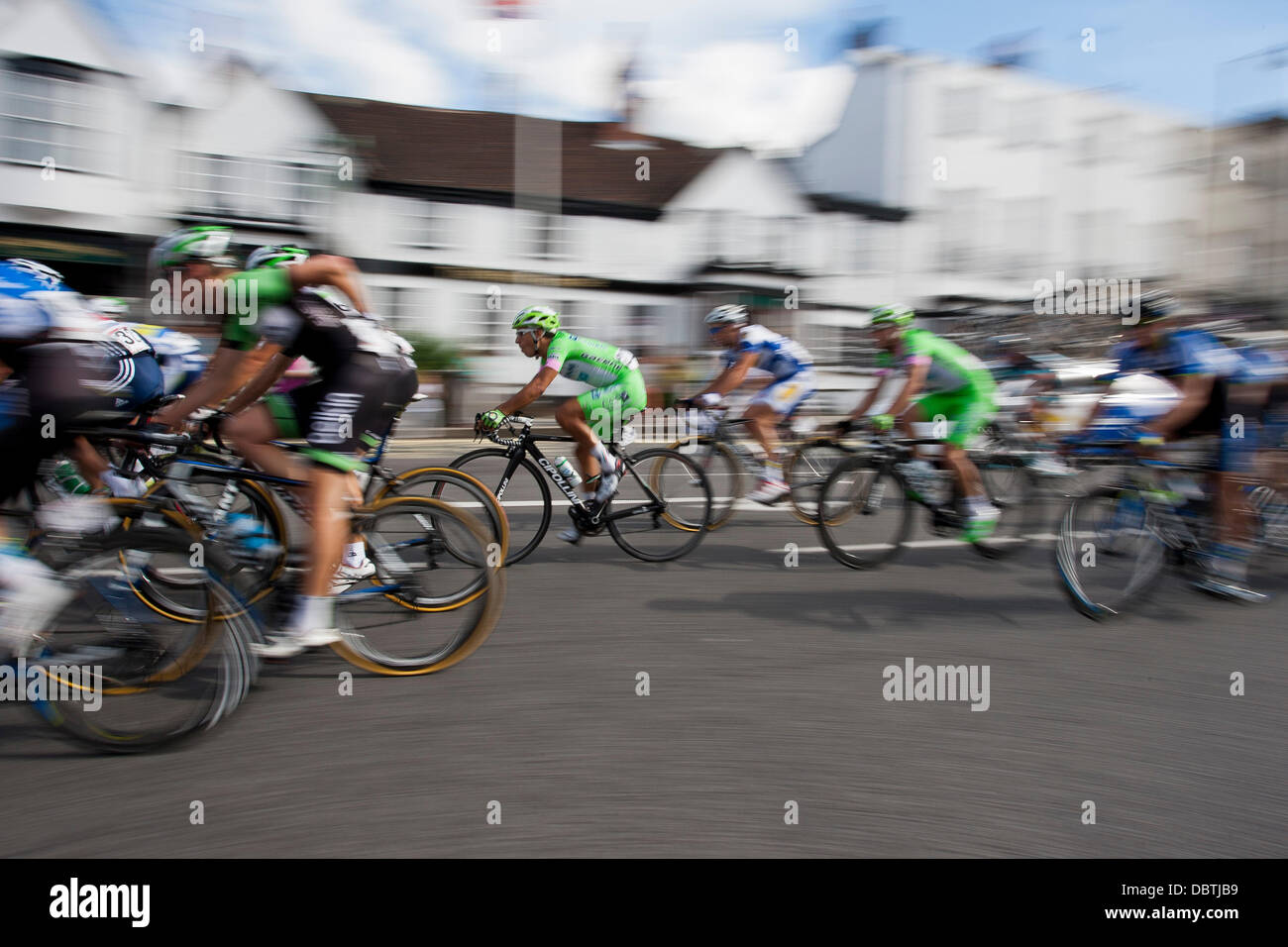 Competitors in the 'Ride London & Surrey' sponsored by Prudential pass down DORKING High Street, Surrey, UK Stock Photo