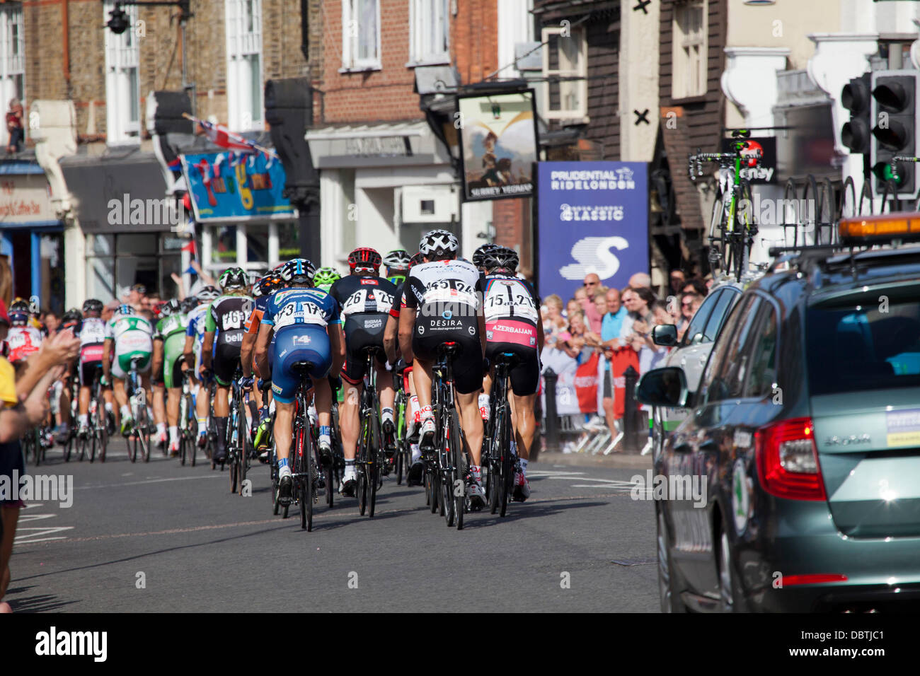 Competitors in the 'Ride London & Surrey' sponsored by Prudential pass down DORKING High Street, Surrey, UK Stock Photo