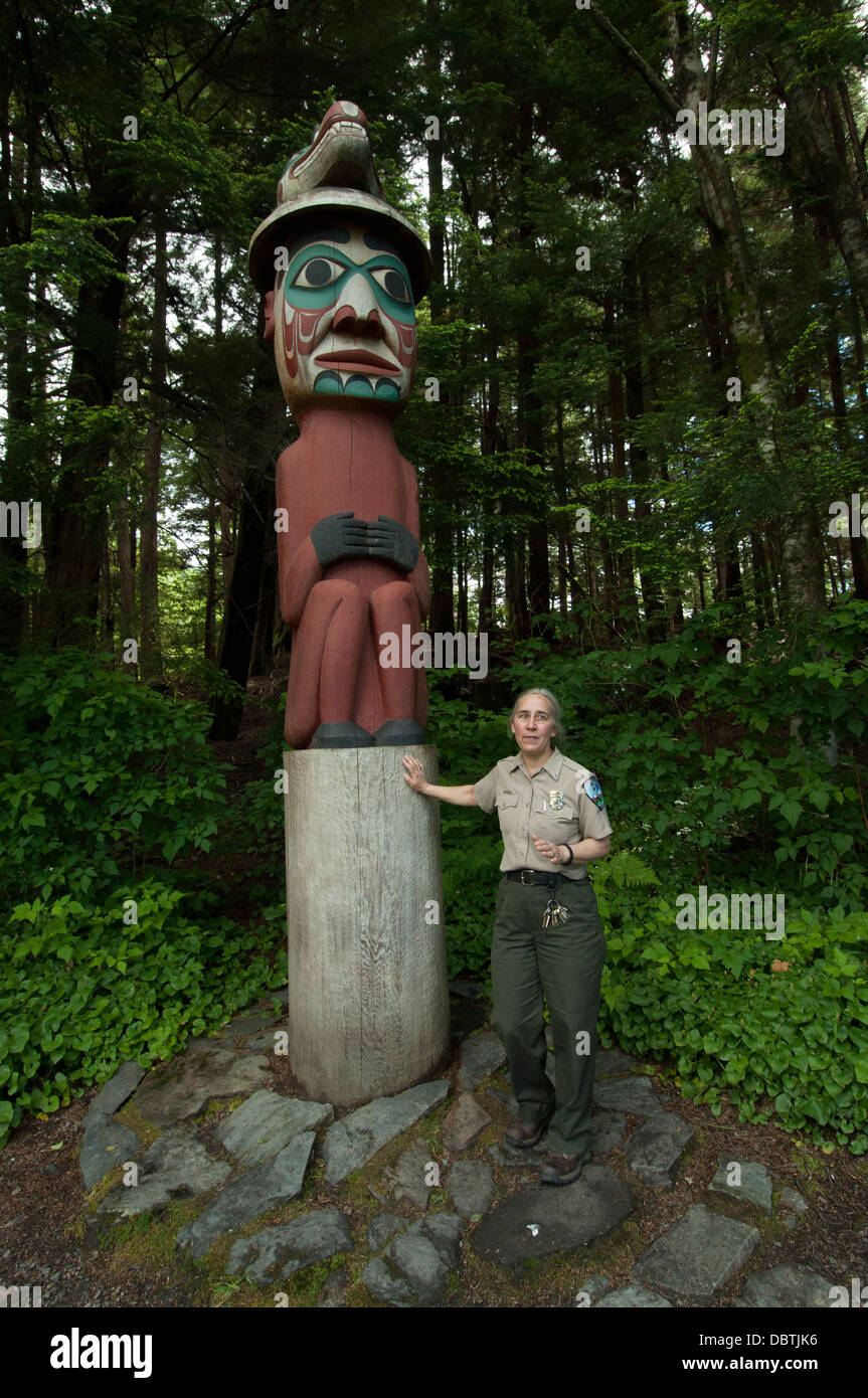 An Alaska State Park ranger stands by a totem pole at Totem Bight State