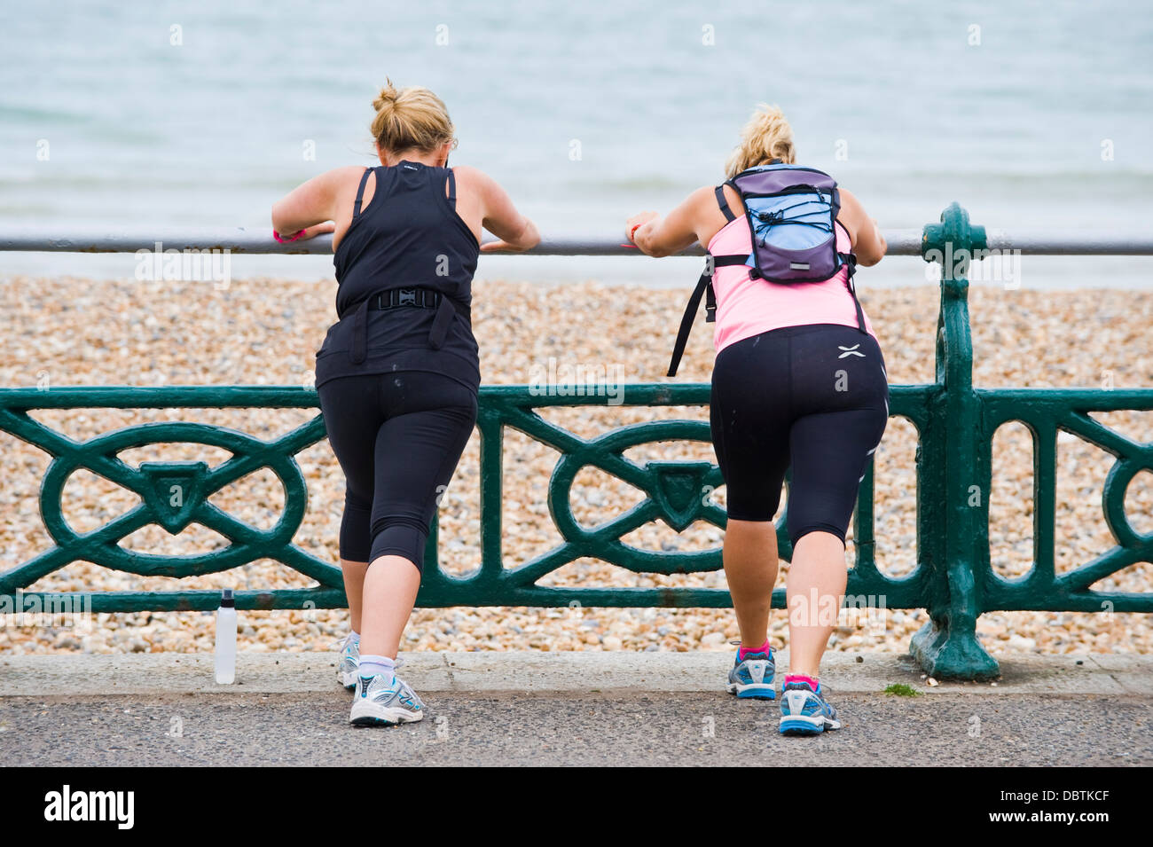 Two mature women having an early morning fitness workout on the beach at Brighton East Sussex England UK Stock Photo
