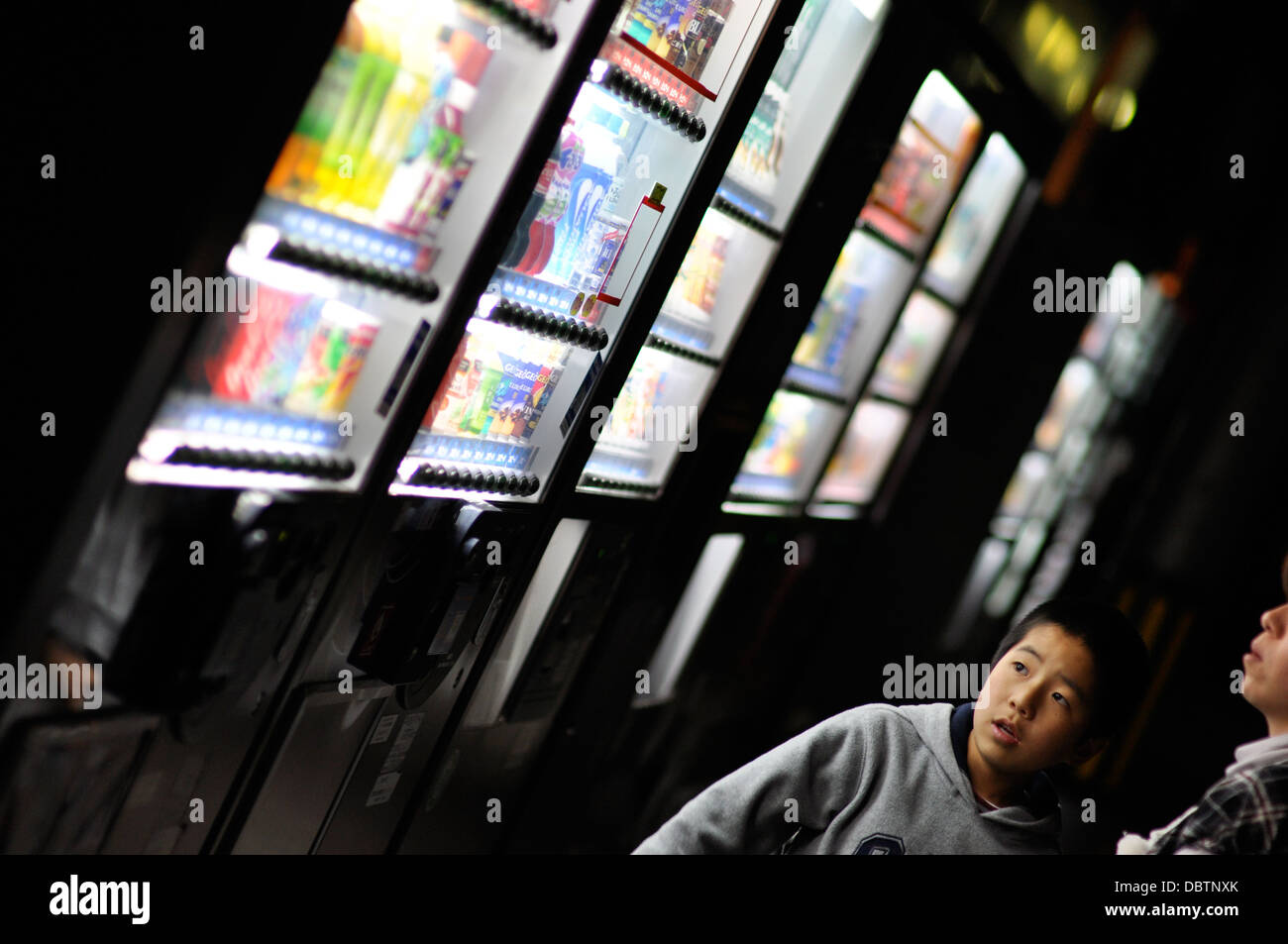 A boy in Japan looking at vending machines selling drinks. Stock Photo
