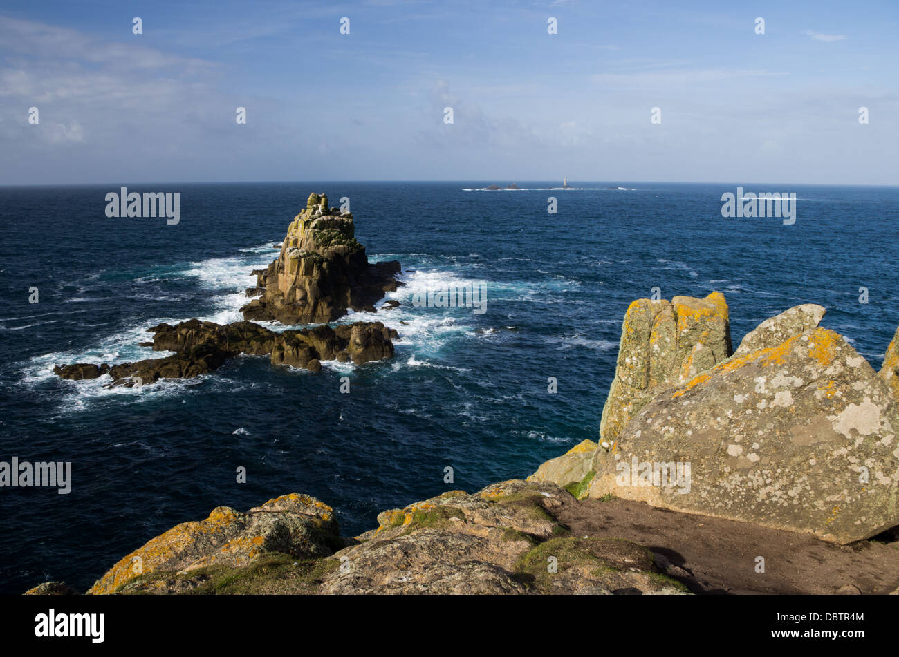 A seaside scene with rocky islands and underwater formations off the coast near Land's End on a clear sunny day. Stock Photo