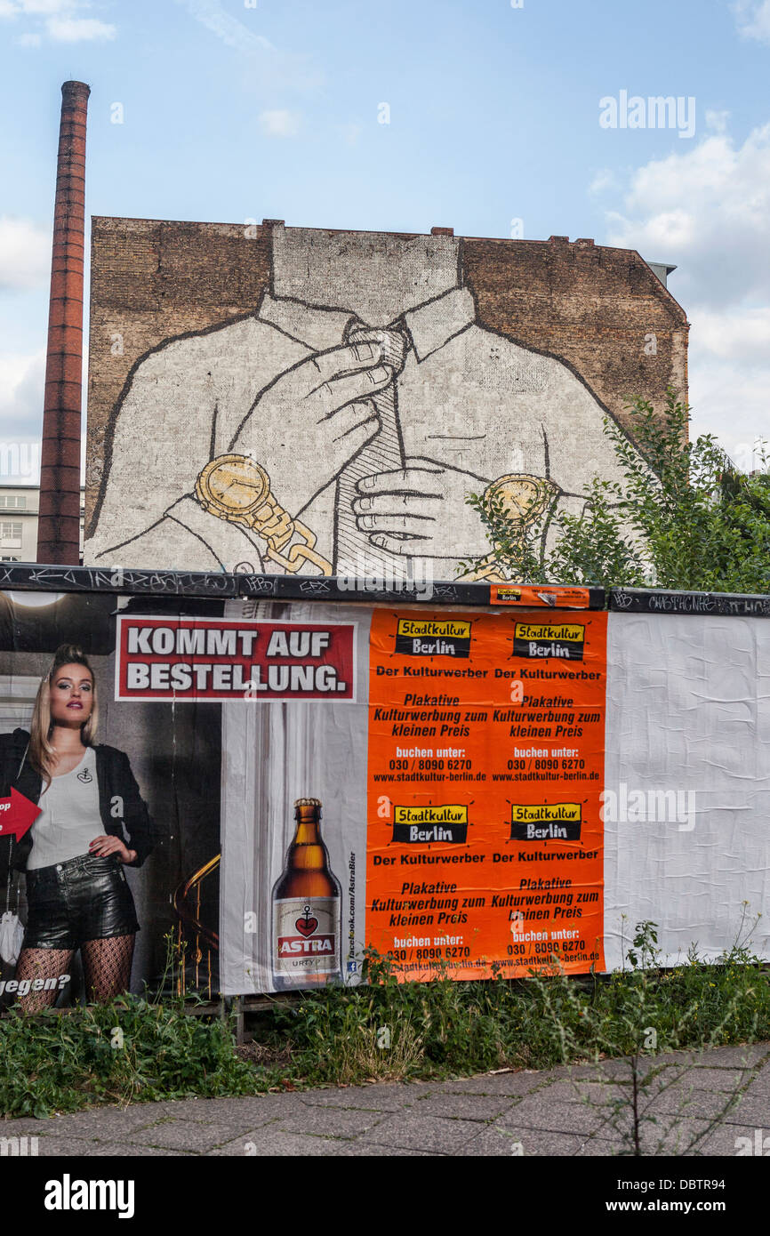 Giant mural by street artist, Blu - a headless, handcuffed man adjusting his tie - Cuvrystrasse, Kreuzberg, Berlin Stock Photo