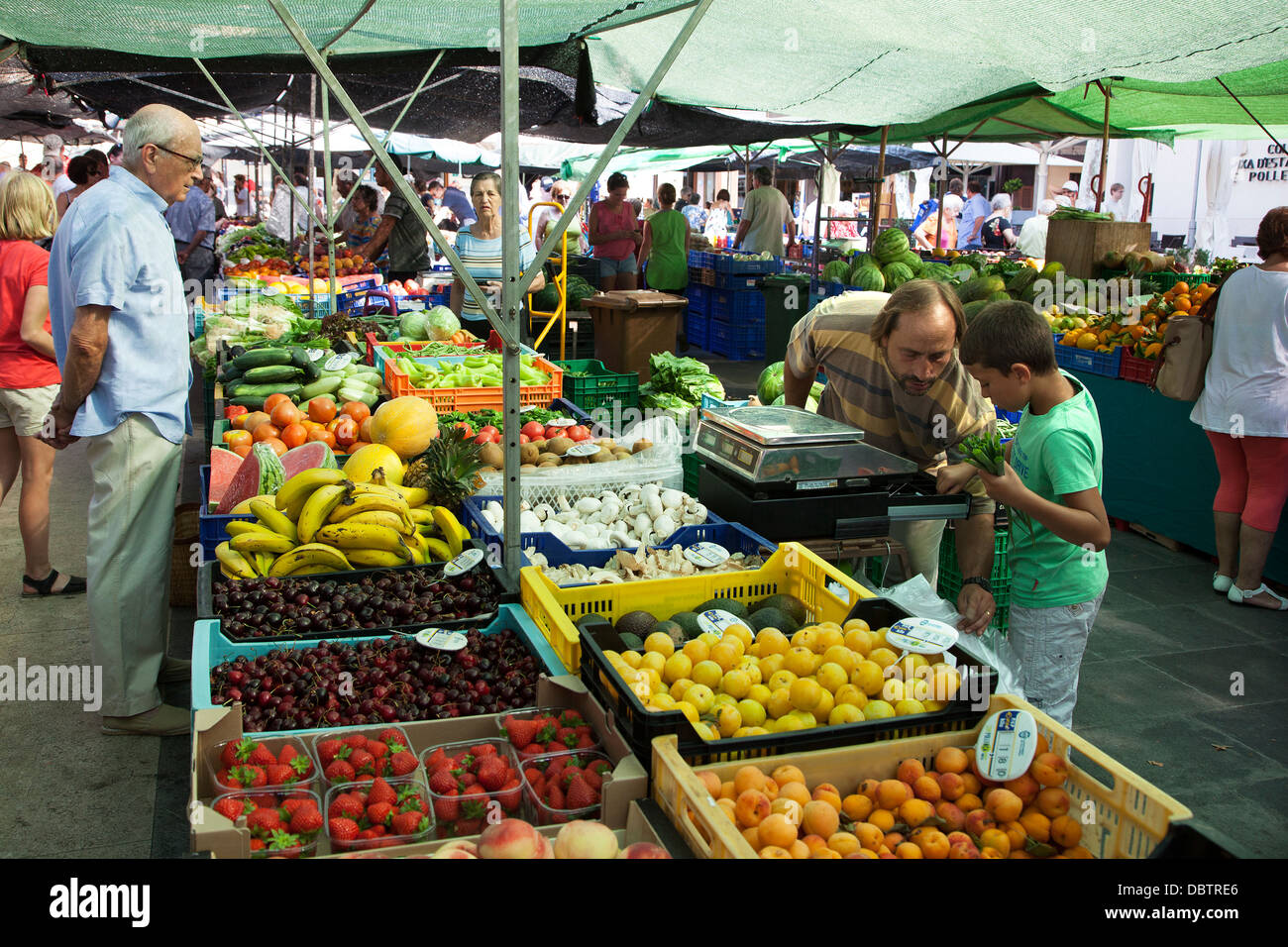 Fruit and vegetable stalls at the Pollensa old town Sunday market in the the main Plaza Mayor square Stock Photo