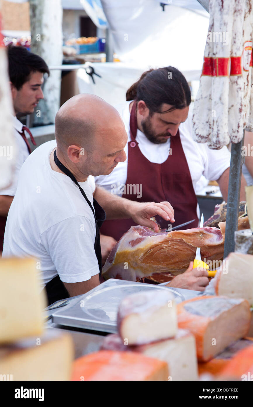 Trader carving Palma Ham at the Pollensa old town Sunday market in the