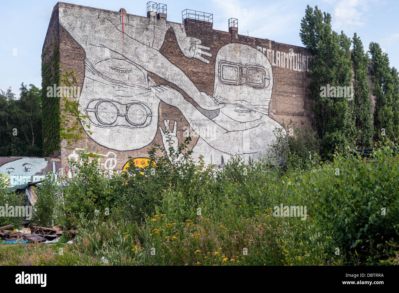 Mural by street artist ,Blu - Two giant white masked men with fingers forming a W and an E - Cuvrystrasse, Kreuzberg, Berlin Stock Photo