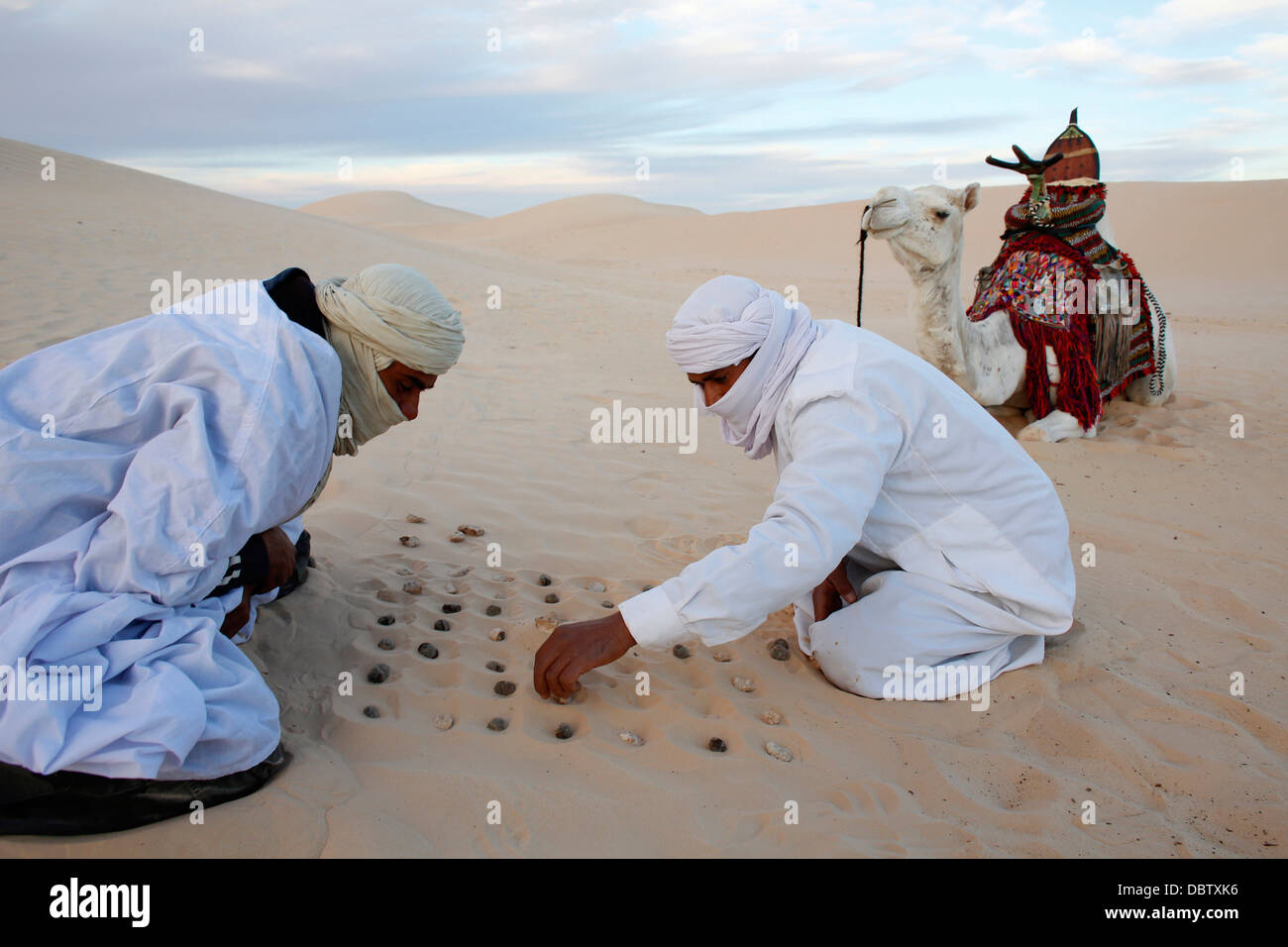 Bedouins playing with stones in the sand, Douz, Kebili, Tunisia, North Africa, Africa Stock Photo
