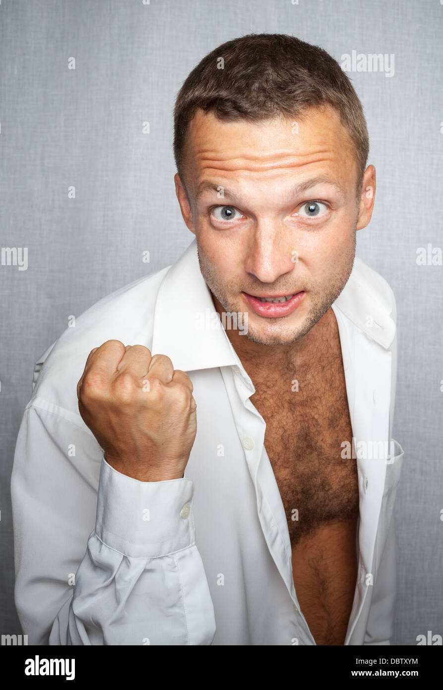 Young Caucasian man in white shirt showing fist Stock Photo