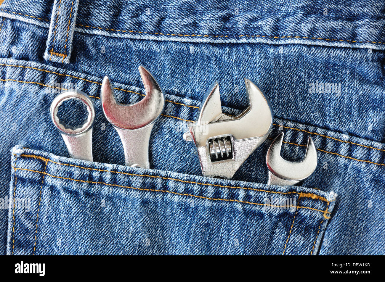 Spanners in the back pocket of a pair of denim jeans Stock Photo