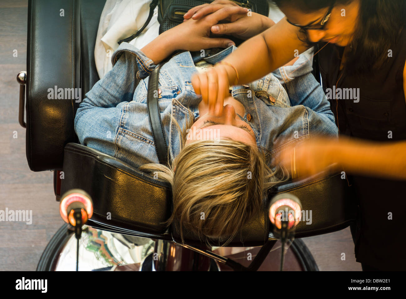 A lady receives a facial beauty treatment from an in store beautician. Stock Photo