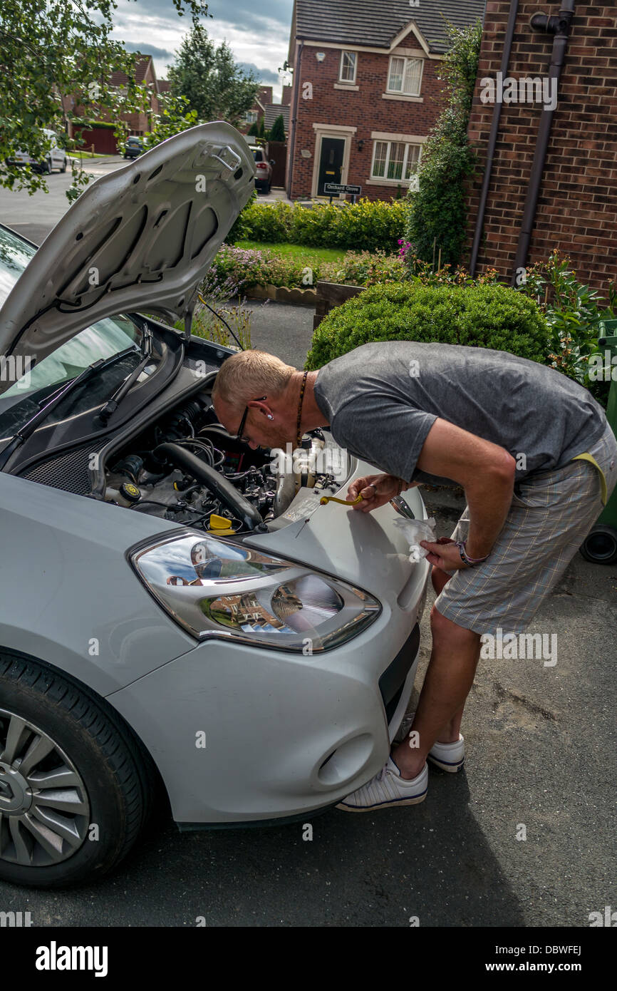 Adult man checking under the bonnet of car, Adult man checking under the hood of car Stock Photo