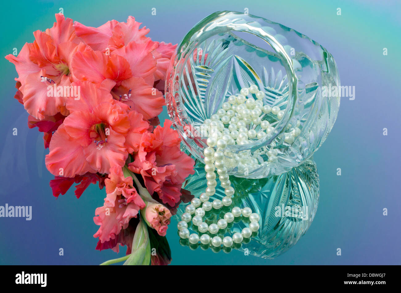 crystal basket in the shape of a ball, pearls and beautiful gladiolus Stock Photo
