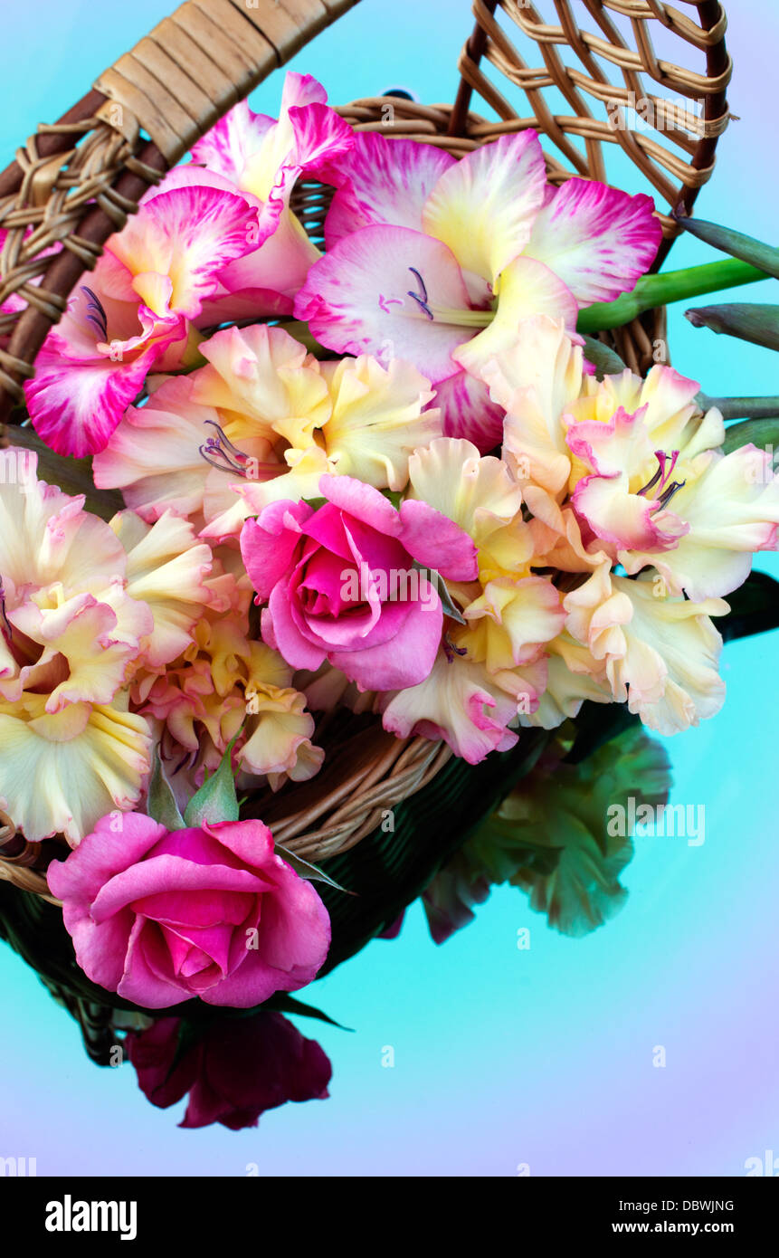 bouquet of gladioli and roses are in a wicker basket Stock Photo