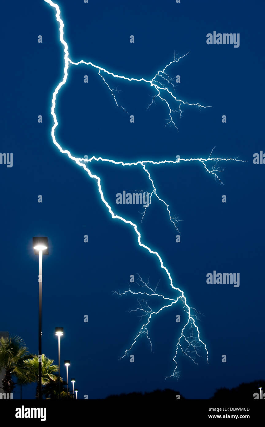 lightning bolt in night sky over street lights Stock Photo