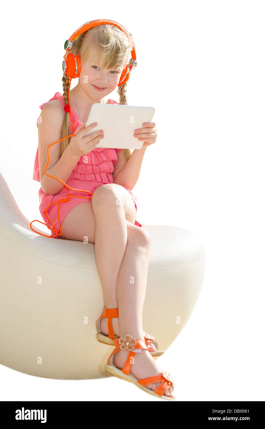Smiling pretty girl sitting on design armchair with orange headphones and using white tablet pc isolate Stock Photo