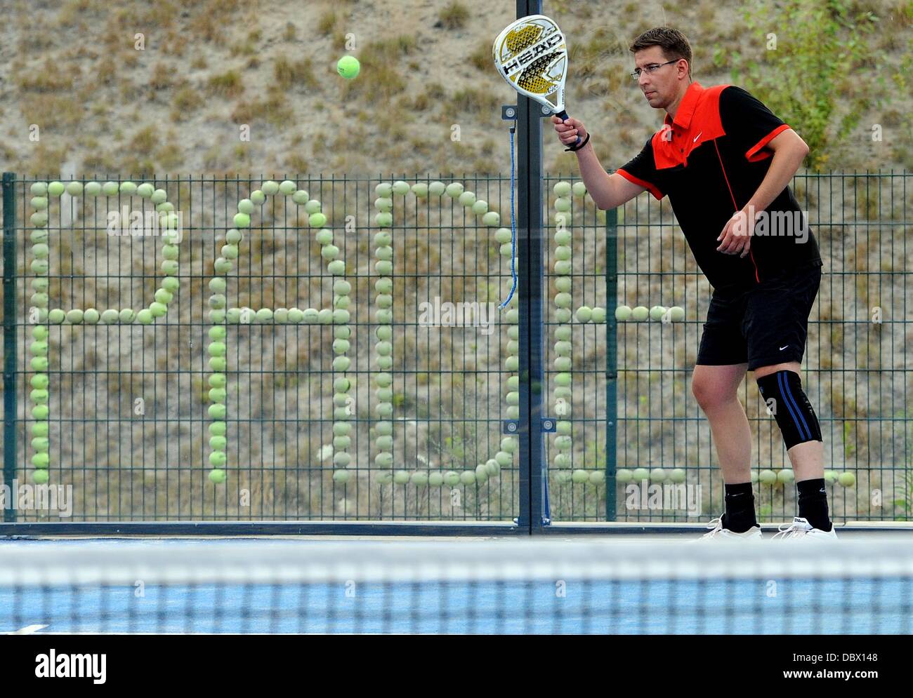 A man returns the ball during a match of padel tennis in Berlin, Germany, 24 July 2013. Photo: Britta Pedersen Stock Photo