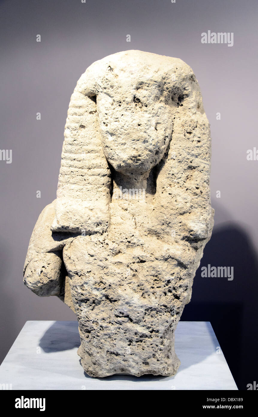 Upper body of a female over life-size statue made of poros stone. It wears a belt and epiblema, a cape preserved over the right shoulder. Typical of the period, the 'daedelic' coiffure is rendered with horizontal and oblique incision. Notches at the back indicate that the statue was attached to some edifice. It is the only oversized statue thus far uncovered in Crete. Astretsi, Archaic period, 7th cent. BC Archaeological Museum of Heraklion - Crete, Greece Stock Photo