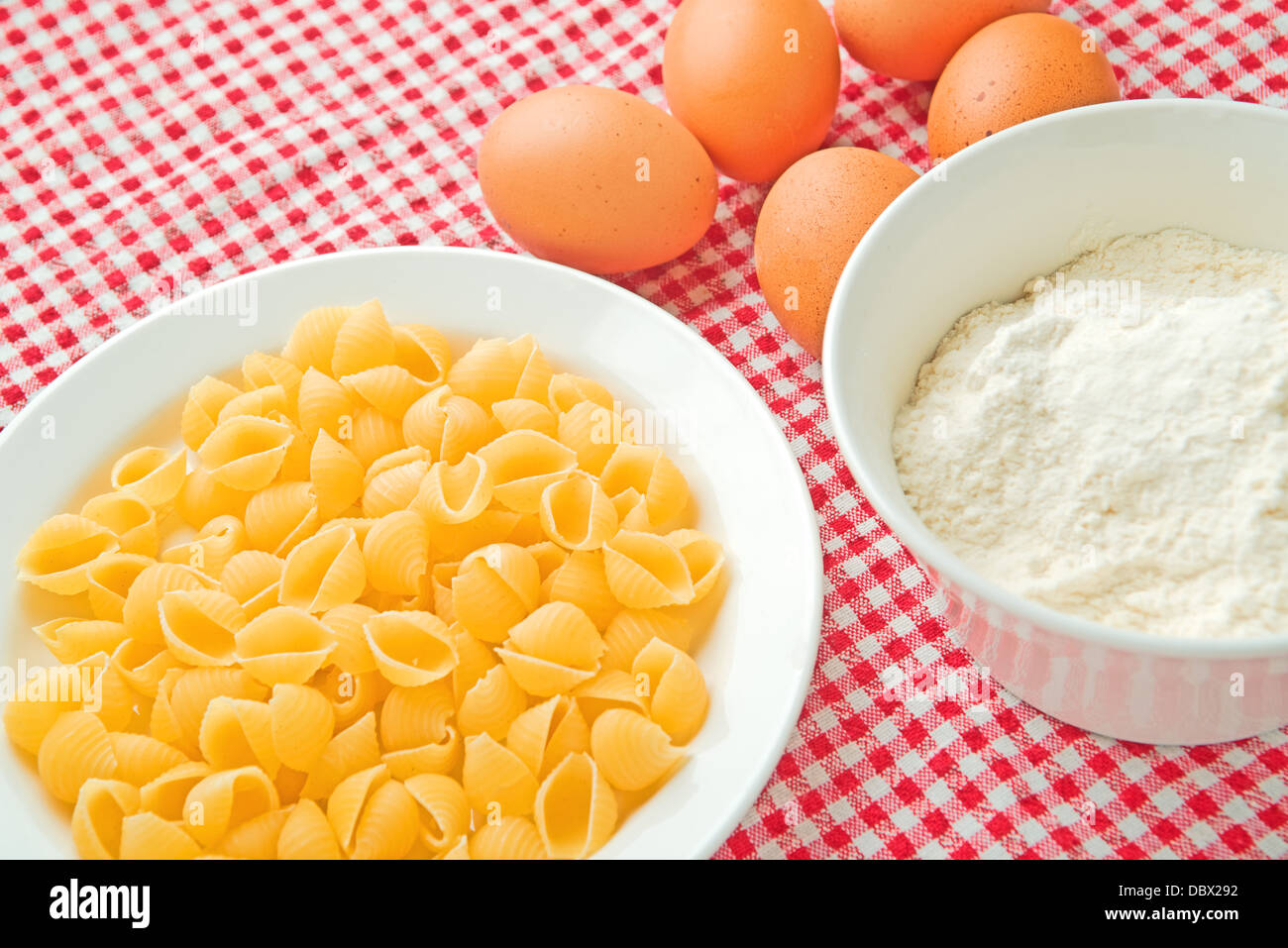 Flour, eggs and pasta on kitchen table, raw food ingredients. Stock Photo
