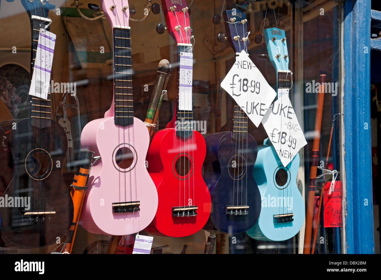 Musical instruments and ukuleles ukulele guitars for sale in shop store window York North Yorkshire England UK United Kingdom GB Great Britain Stock Photo