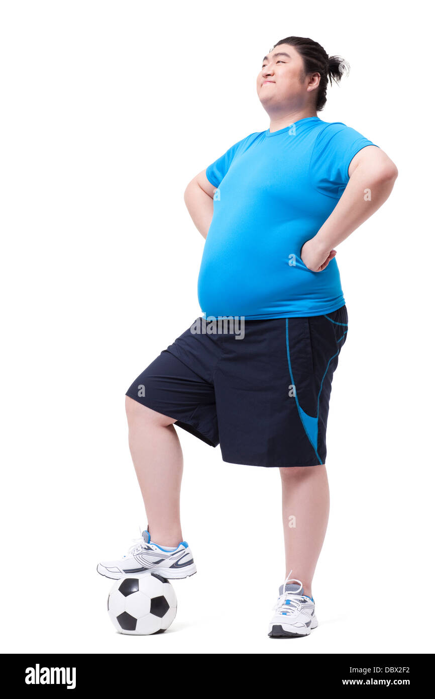 Cheerful fat man with foot on football Stock Photo