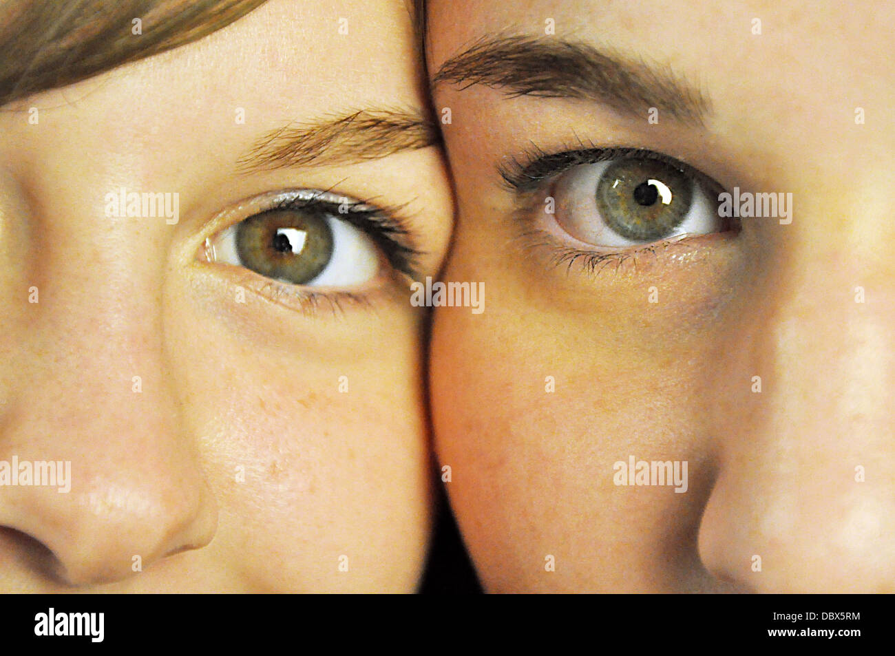 A closeup of two girls, side by side, with hazel eyes Stock Photo