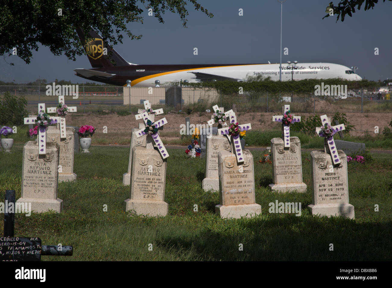 McAllen, Texas - La Piedad Cemetery, next to a UPS cargo jet waiting at McAllen-Miller International Airport. Stock Photo
