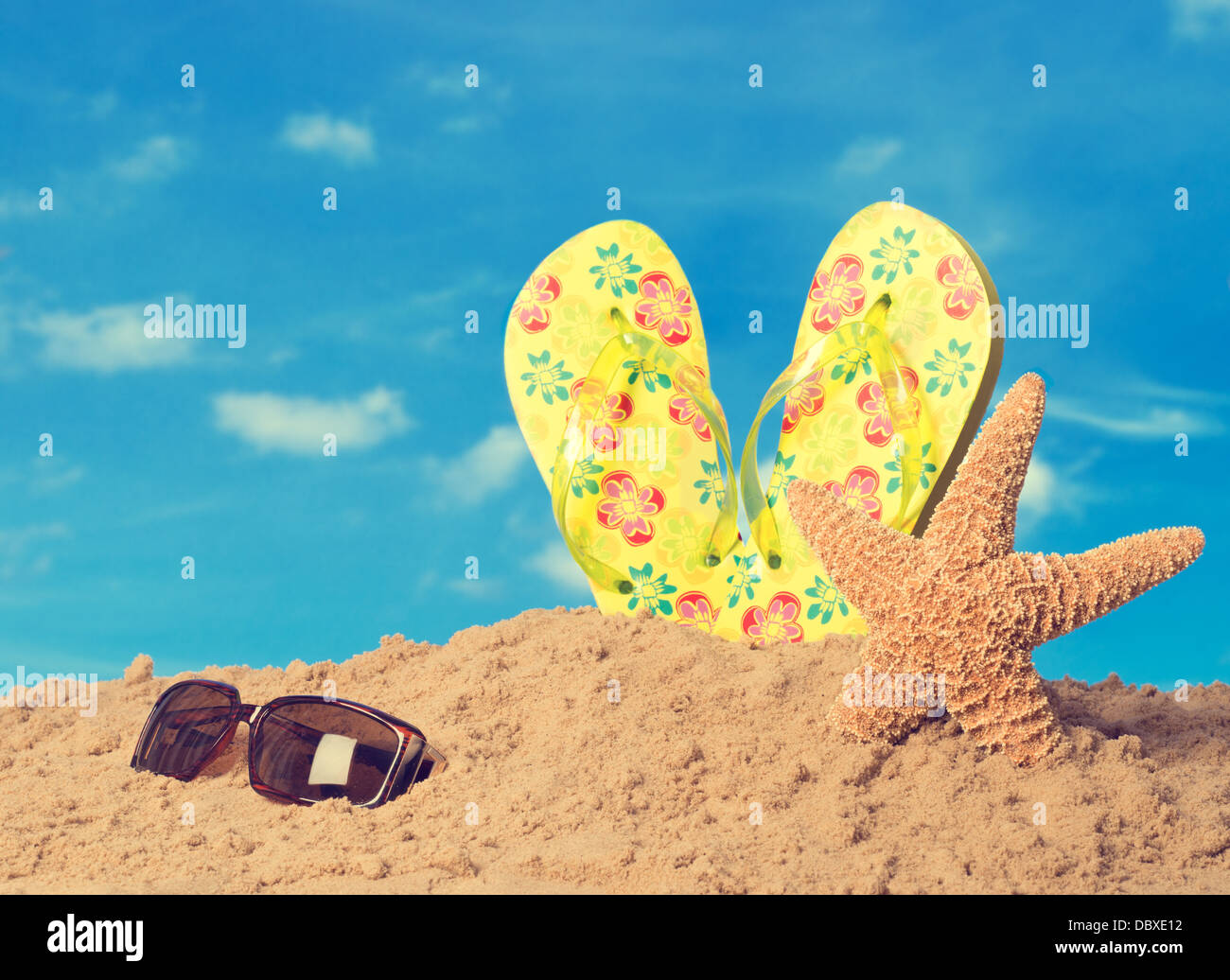 Sunglasses on sandy beach with flip flops and starfish against summer ...