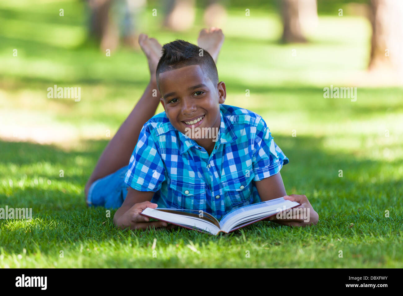 Outdoor portrait of student black boy reading a book - African people Stock Photo