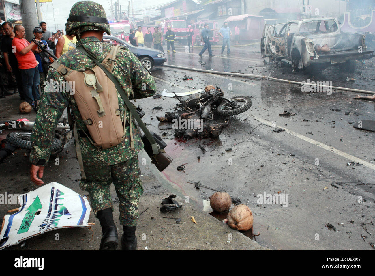 Cotabato, Philippines. 5th Aug, 2013. Bodies lay burnt in the street following a deadly car bomb explosion in the busy street of southern Philippine city of Cotabato. The deadly blast killed at least six people and wounded 29. It detonated as a car passed carrying a local official, who escaped unhurt. It was not clear if she was the target. Cotabato is on the island of Mindanao, which has been racked by a 40-year conflict between government forces and Islamist rebels. It is the second deadly bombing on Mindanao in 10 days. Stock Photo