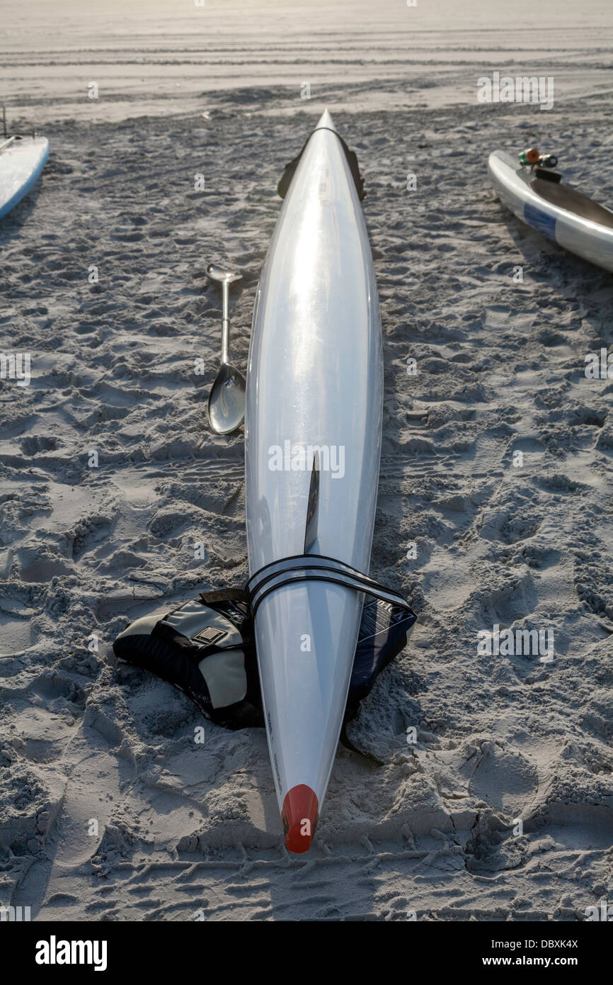 White ocean sea kayak sitting on beach at the surf line Stock Photo - Alamy