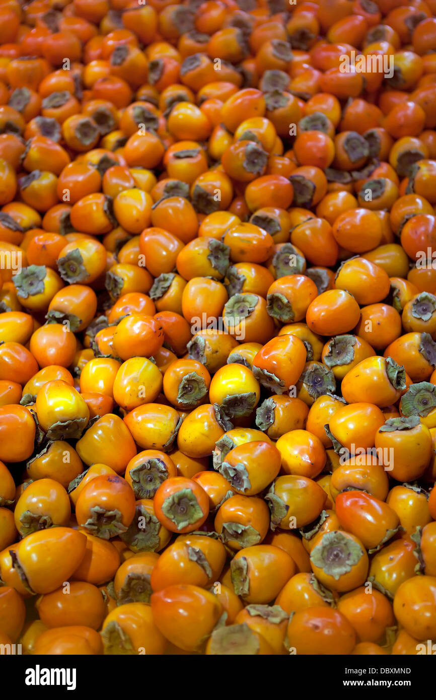 Heart-shaped Hachiya Persimmons, genus Diospyros, for sale in a wholesale fresh produce market in Quebec, Canada. Stock Photo