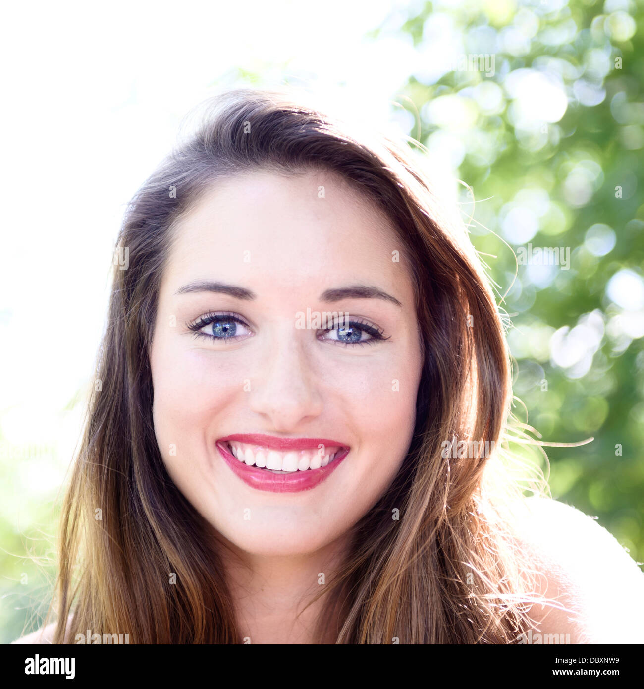 Close-up headshot of a young woman smiling. Stock Photo
