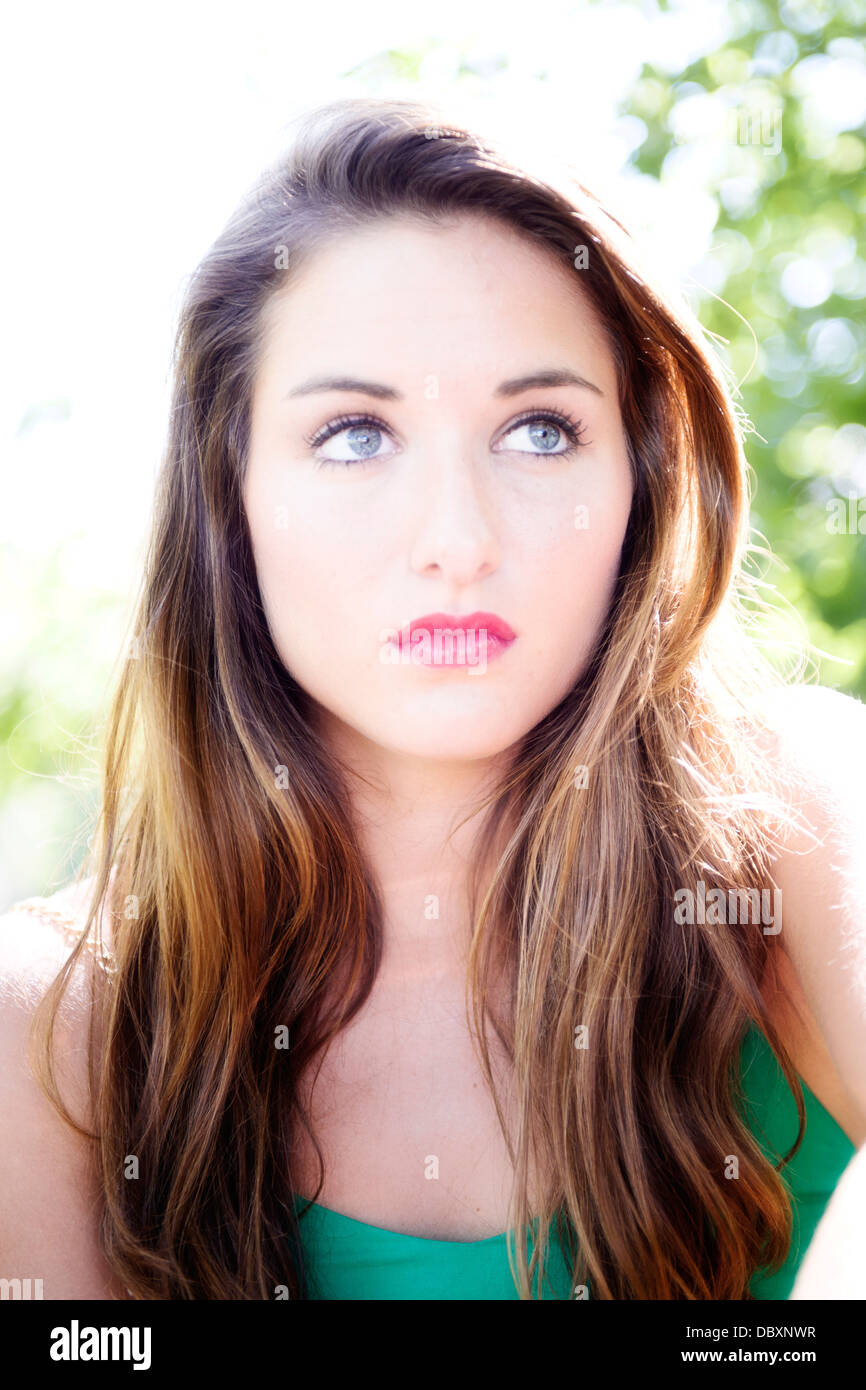 Portrait photo of an attractive young woman with brunette hair and blue eyes. Stock Photo