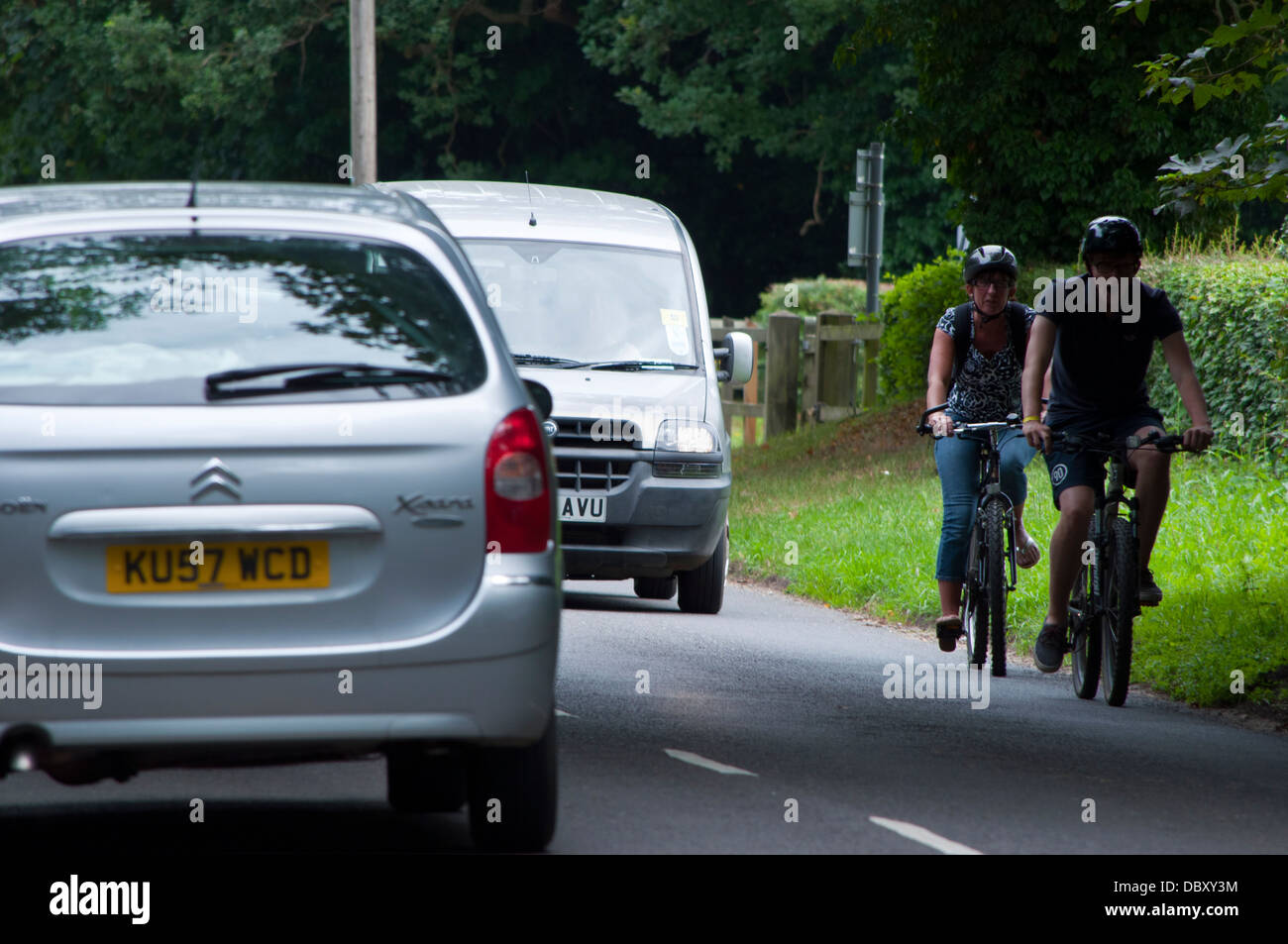 People cycling on busy country road cyclist Stock Photo