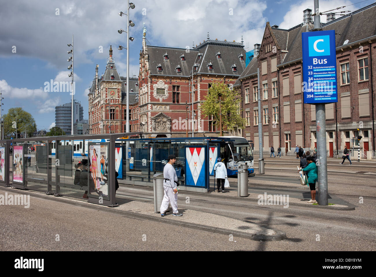 City infrastructure, bus stops and Central Train Station Neo-Renaissance building in Amsterdam, Holland, Netherlands. Stock Photo