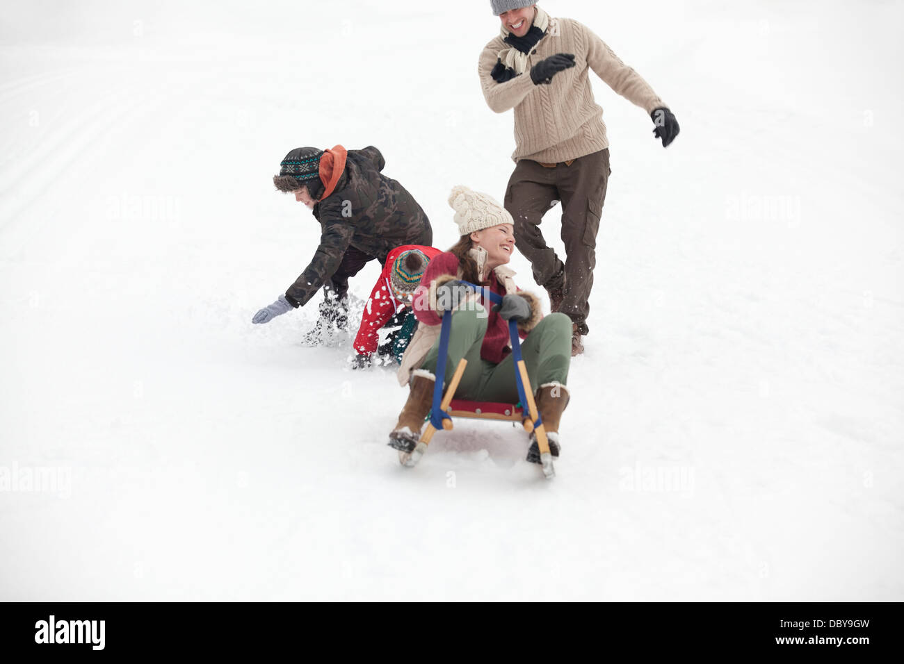 Family sledding in snowy field Stock Photo