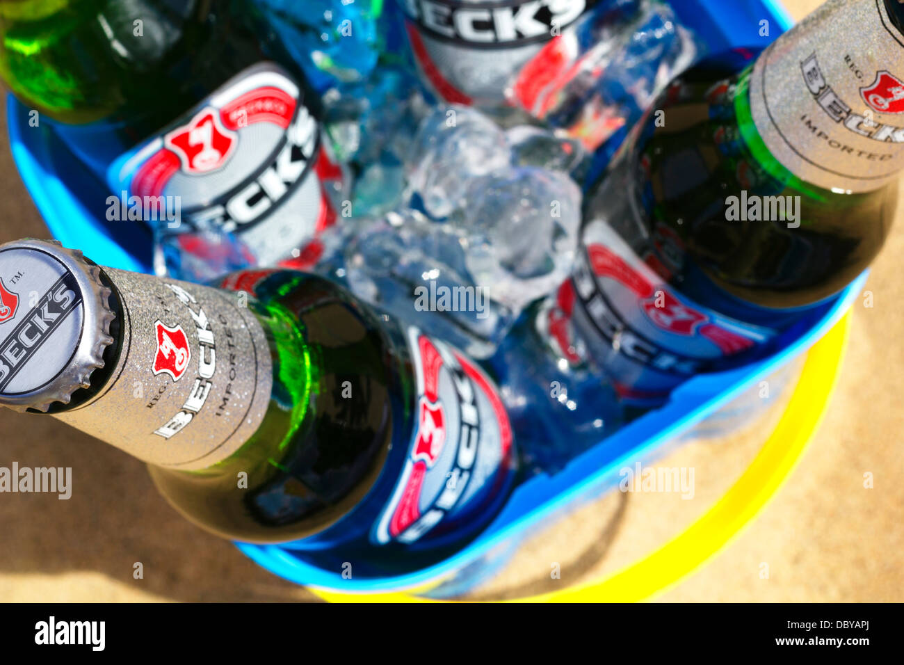 Becks Beer Bottles With Ice In Sand Castle Bucket On Beach. Stock Photo