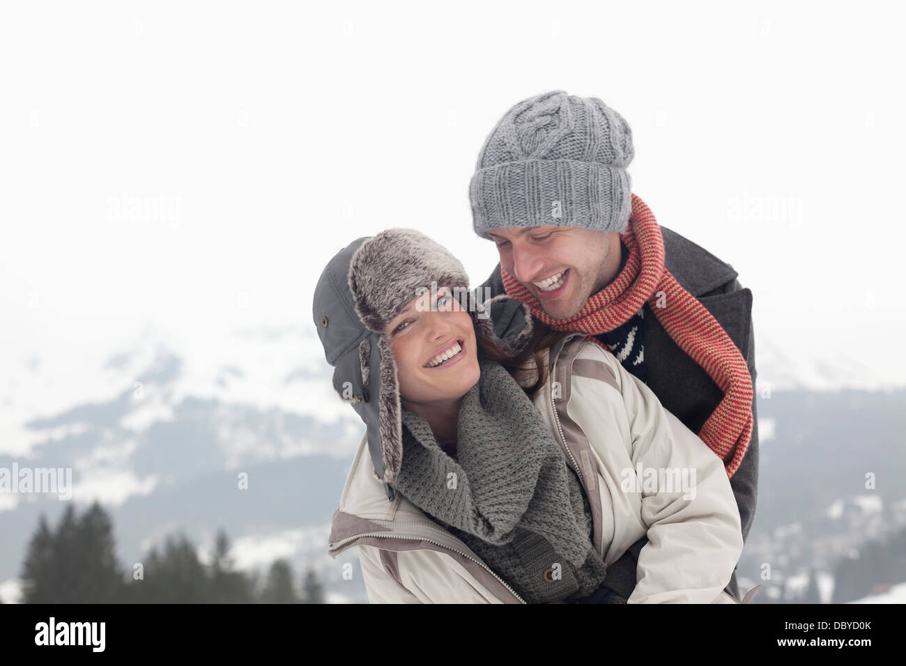 Portrait of enthusiastic couple hugging with mountains in background Stock Photo