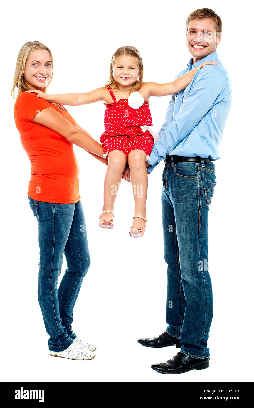Baby girl sitting on outstretched arms of her parents Stock Photo